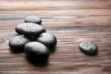 Black stones for therapy on wooden background