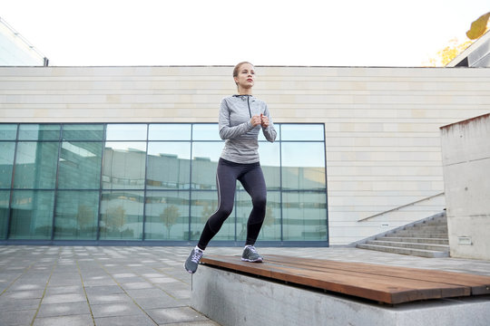 woman making step exercise on city street bench
