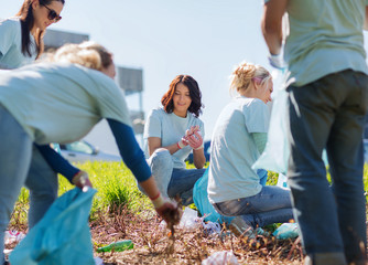 volunteers with garbage bags cleaning park area