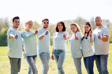 group of volunteers showing thumbs up in park