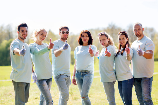group of volunteers showing thumbs up in park