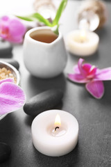 Fototapeta na wymiar Beautiful spa set with candle and orchid on the table, close up