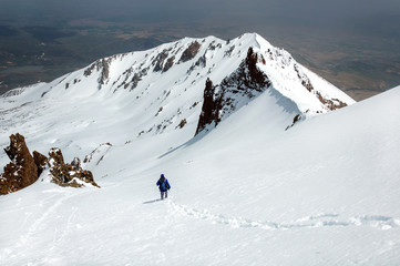 Naklejka na ściany i meble Male climber descends from the top of Erciyes volcano.