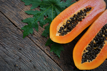 Top view Ripe papaya with green leaf on old wooden background.