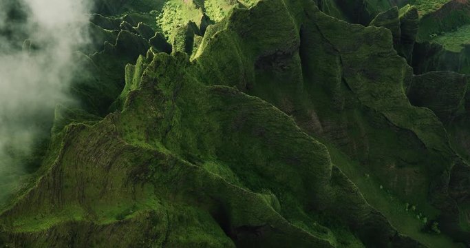Aerial view flying over jungle mountain peaks revealing tropical coastline, Na Pali coast Kauai