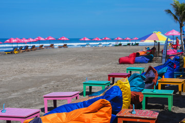 empty cushioned chairs and loungers on the beach