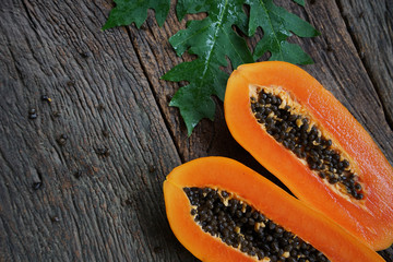 Top view Ripe papaya with green leaf on old wooden background.