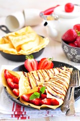 Pancakes with organic strawberries, caramel, cinnamon and mint.