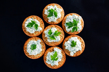 Bisquit cracker appetizers with cottage chees and parsley topping