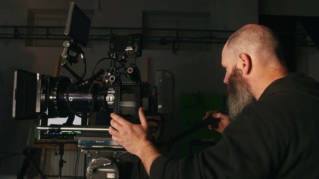 Camera operator waiting for que on pan shot in studio environment