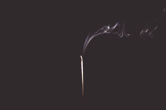 Incense Stick with Smoke on Black in black and white abstract background.