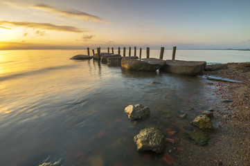 Fototapeta na wymiar sea landscape, boulders in the water,sunset and colorful sky, slow shutter speed