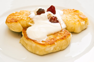 Cheesecakes with sour cream and jam on a plate