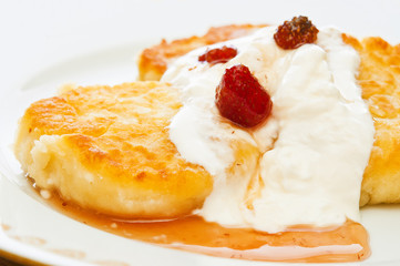 Cheesecakes with sour cream and jam on a plate