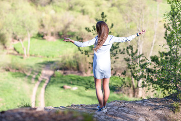 Young beautiful woman standing on the edge of a cliff