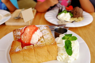 A luscious honey toast with vanilla ice cream on top   whipped cream and strawberry jam © toptodown
