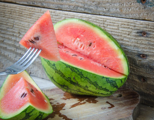 Sandía pequeña cortada con fondo de madera rústica