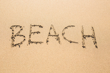 word Beach written on the sand