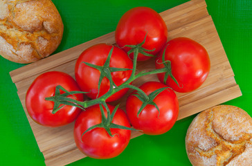 Breakfast - Two wheat bread and red tomatoes on the wooden table