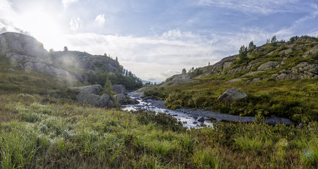 panorama of mountain scenery in sunny day with meadow, located in a river valley in Abkhazia, Caucasus Mountains
