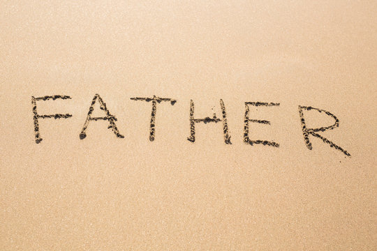 Father hand written in the sandy beach