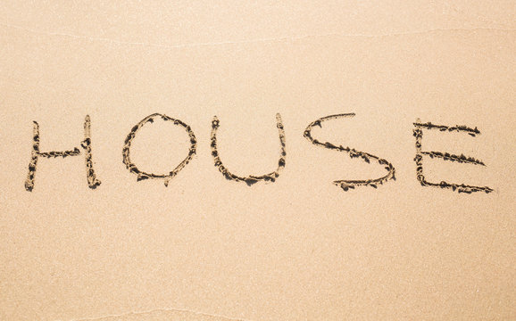 word house written in sand on beach