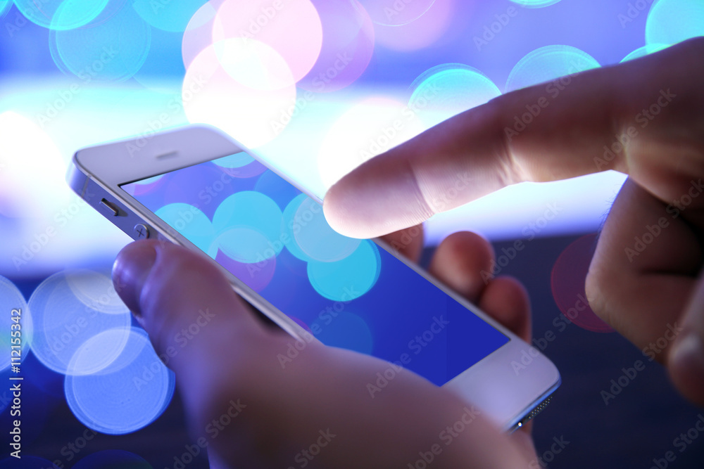 Poster Mobile phone in man's hand, night, city background with lights