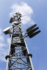 Cell phone transmitters on telecommunication tower on sunny day