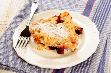 home made cherry crumble with powdered sugar on a plate