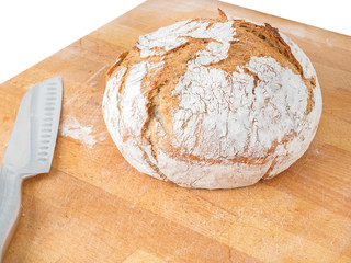 homemade round bread with a knife on a board