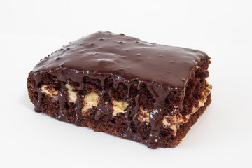 Piece of chocolate cake with icing on white isolated background