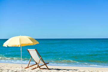 Chair and umbrella on stunning tropical beach background vacation 