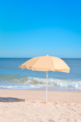 Fototapeta na wymiar Sun parasol on the sandy beach ocean sky