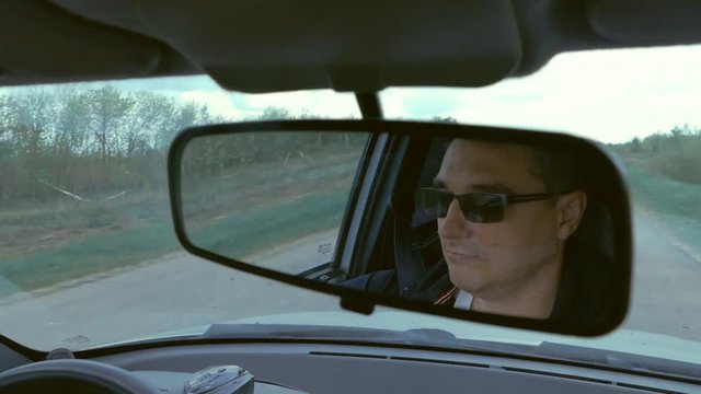 a man behind the wheel of a moving car slow motion video
