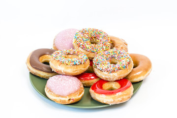 A plate of the  colorful glazed donuts with sprinkles