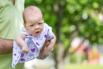 Father playing with her newborn baby daughter