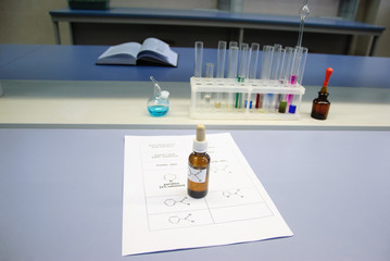 Flask with a chemical reagent on a sheet of paper with chemical