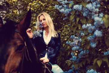 Naklejka premium Blond female sitting on horse back.