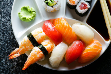 Sushi Set nigiri and sushi rolls served on black marble slat