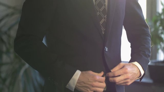 Elegant business man in white shirt buttoning his suit jacket. close up