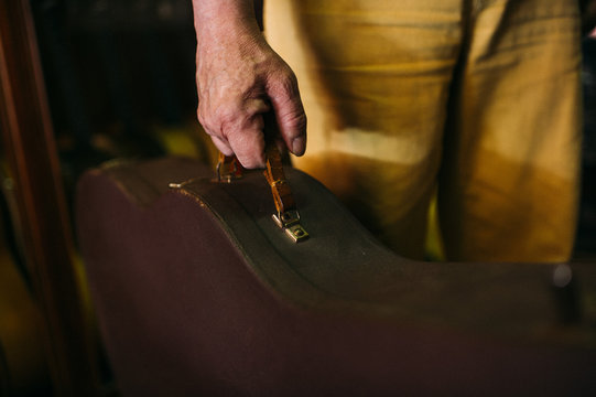 Luthier holding a sheath of a violin in his workshop
