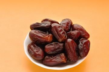 Dates fruit on yellow background. Ramadan fruits.