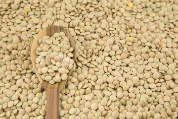 scattered raw lentils and wooden spoon