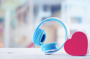 Obraz na płótnie Canvas Blue headphones with heart on defocused background