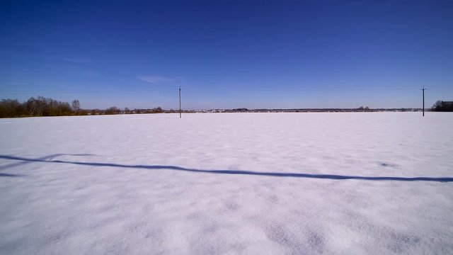 The plaine snowy field on a morning. Sunny day yet thick snow are on the ground from the winter season