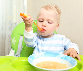 Cute little child eating blended carrot