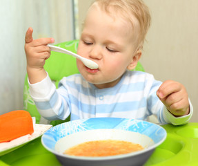 Cute little child eating blended carrot