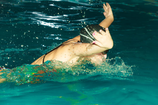 Woman athlete swimming butterfly stroke in pool.