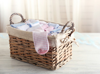 Obraz premium Baby socks in wicker box on wooden table