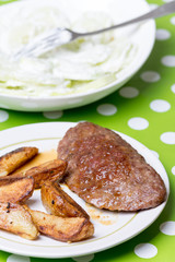 Hamburger with potatoes and cucumber salad